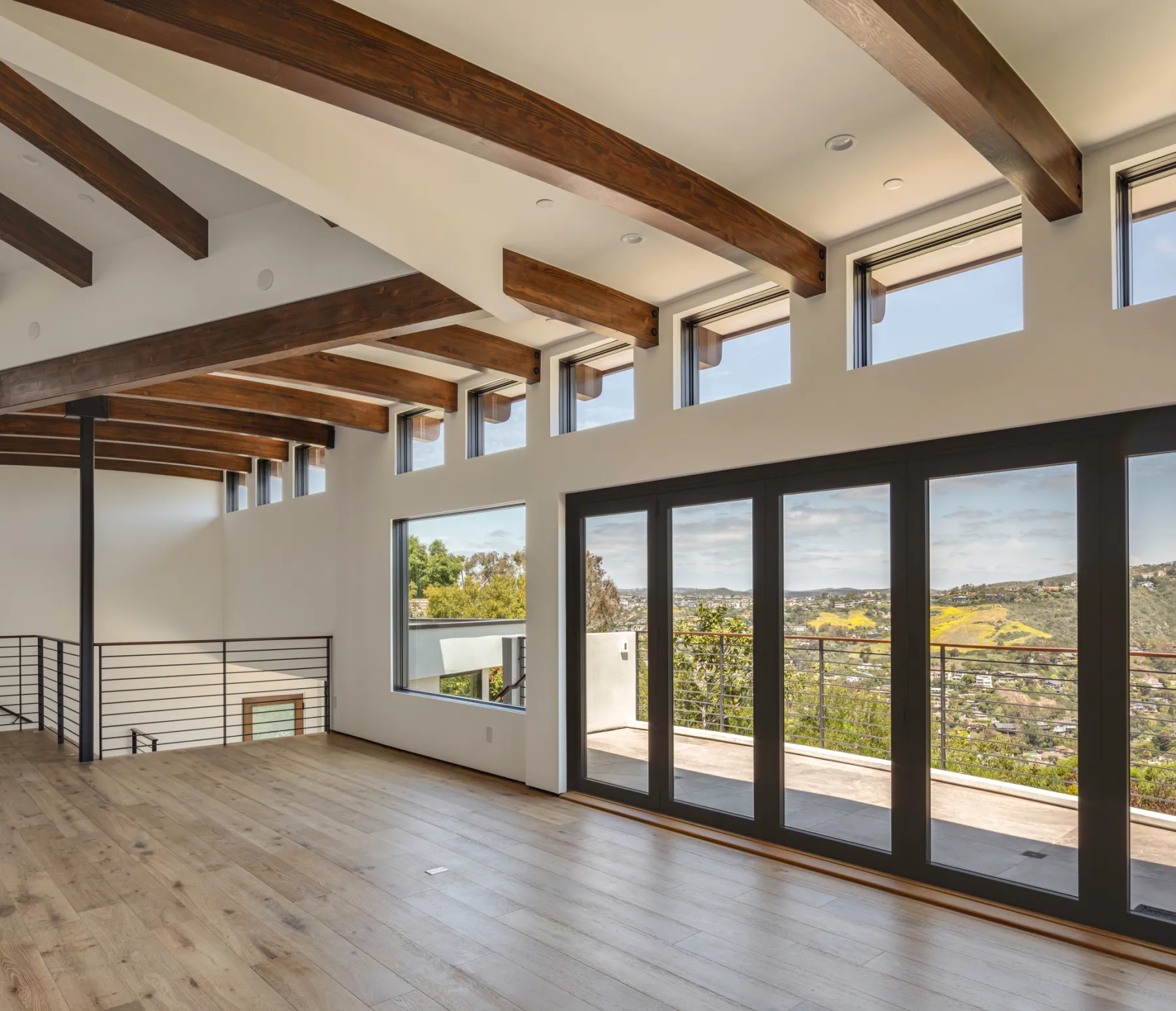 Living space with exposed beams and doors opening to the view