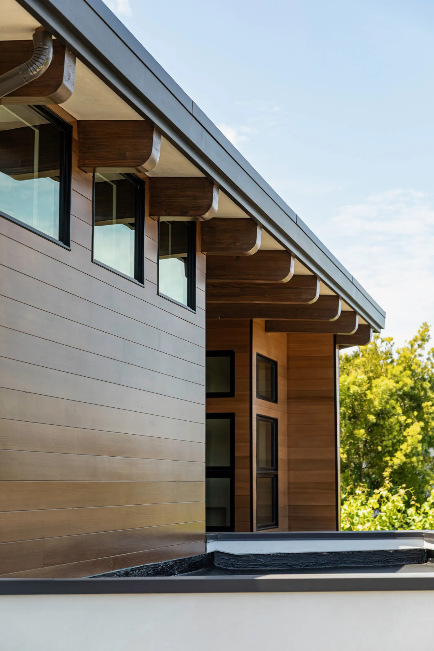 Home exterior with wood-clad walls and exposed timber eaves