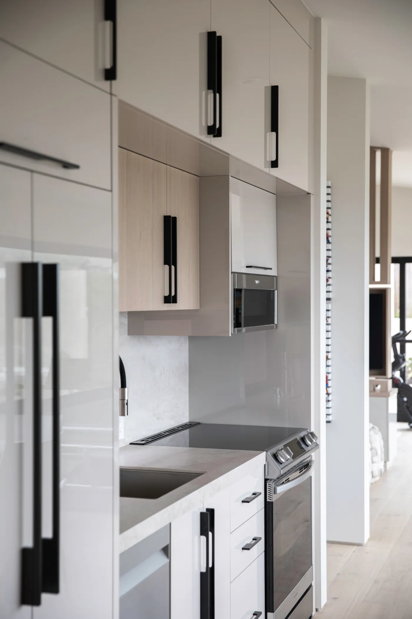 Kitchen with tall white cabinetry and black pulls