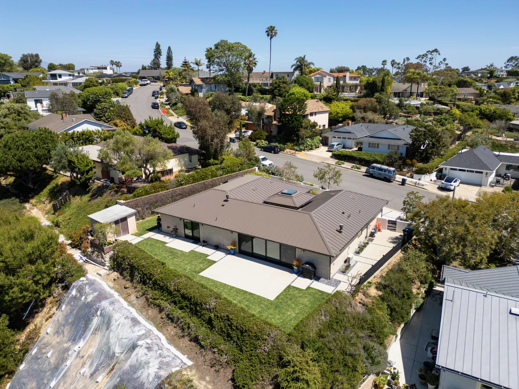 Aerial view of a single-story home on a hillside lot in a Laguna Beach neighborhood