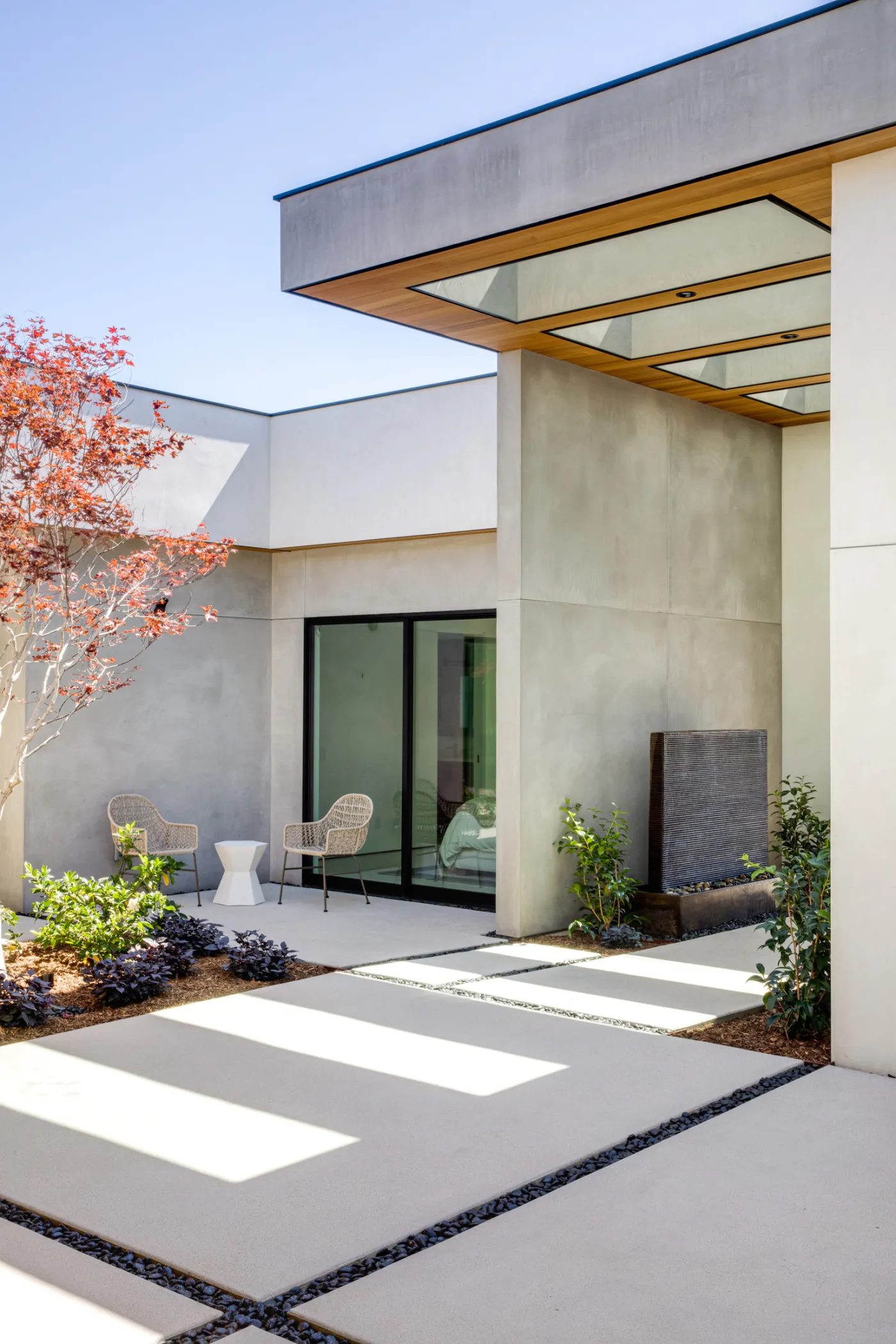 Courtyard entry with a cantilevered canopy and concrete pavers