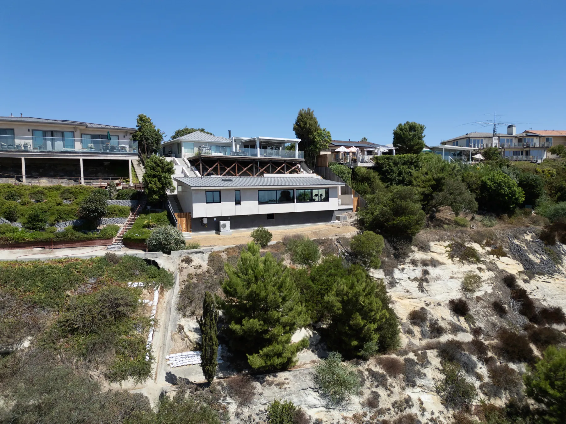 Home perched on a steep Laguna Beach hillside above an eroded cliff face